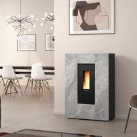 Un espace de vie moderne est doté d'un élégant poêle gris EXTRAFLAME avec un affichage de flamme vertical. La pièce présente un design minimaliste avec des chaises de salle à manger blanches autour d'une table en bois, un luminaire géométrique et des œuvres d'art murales abstraites. Les murs sont beige clair, ajoutant une chaleur subtile au décor inspiré de Marilena.